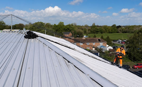 Bird netting tensioned from a central pole over a large industrial roof