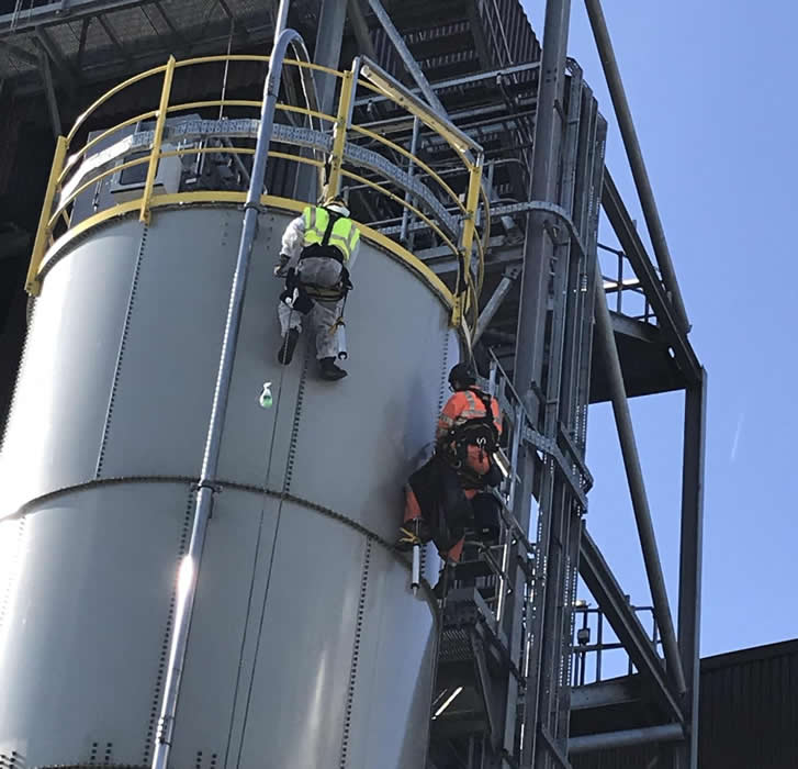 Large industrial silo undergoing a full repaint